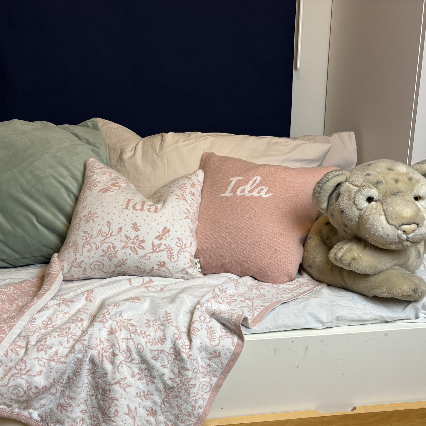 rosa och vit filt på en säng med namnet Ida